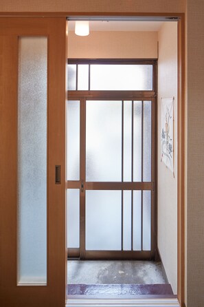 A traditional Japanese room with sliding doors, tatami flooring, and a shoji screen.