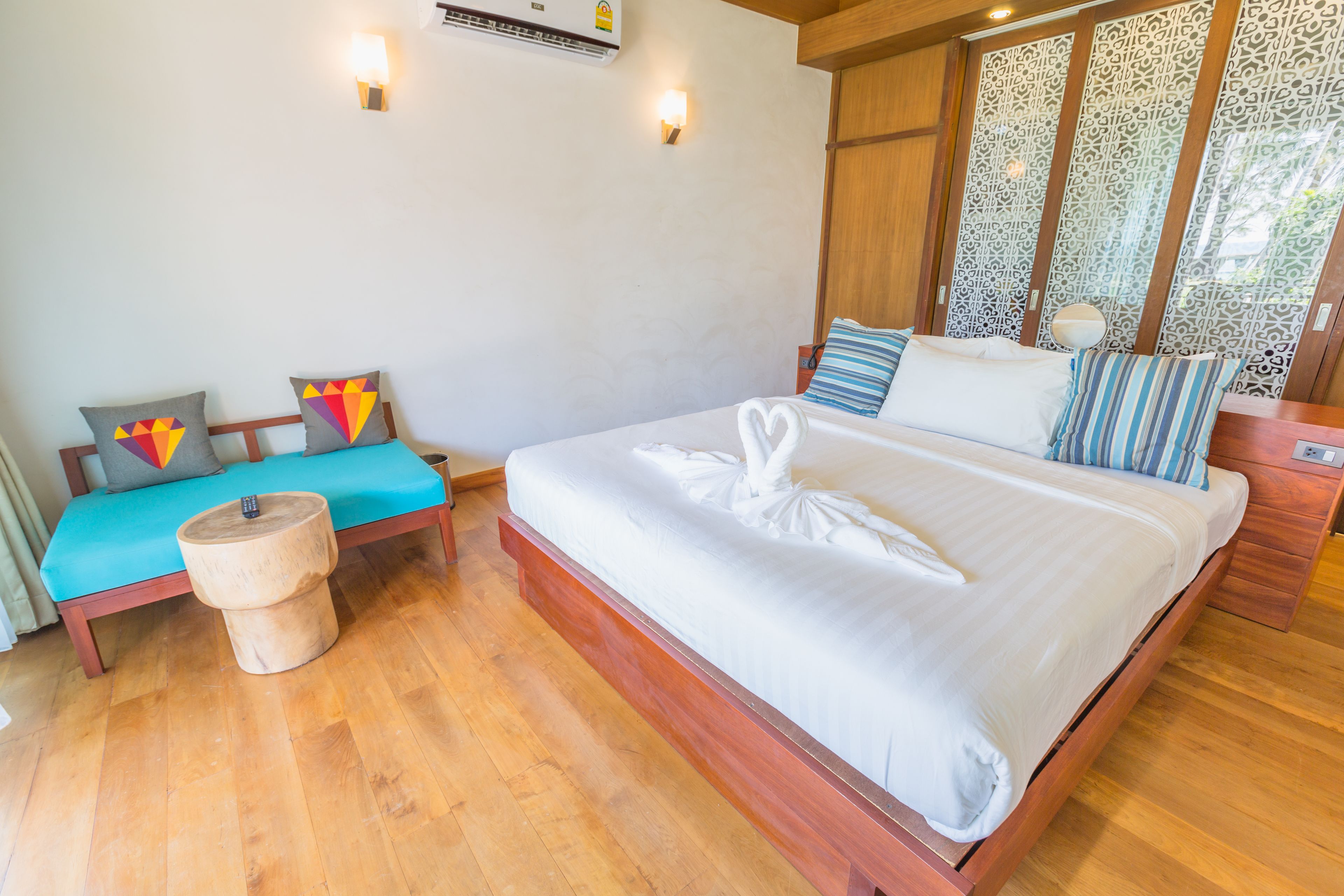 Ein Schlafzimmer mit einem hölzernen Bett, einer Holzbank und einem kleinen runden Tisch.