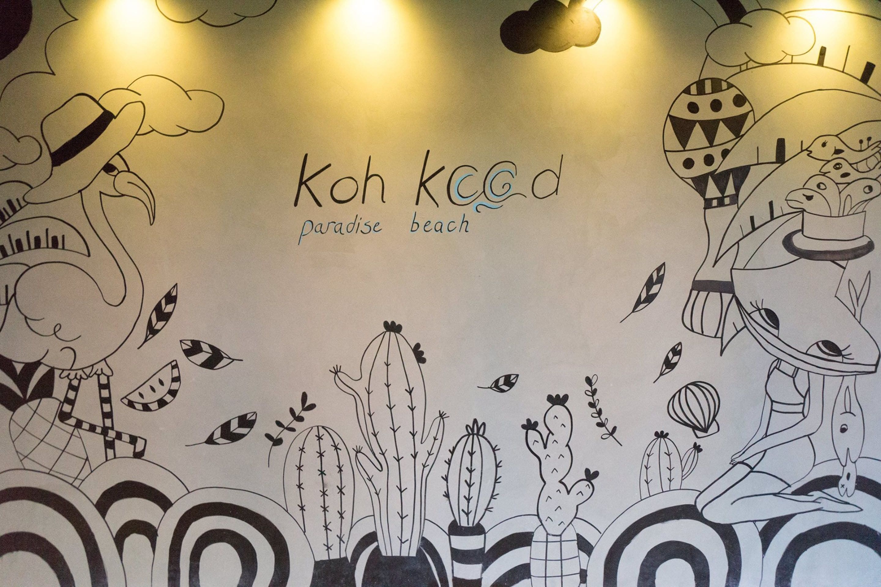 Un muro con un dibujo de cactus y una persona, y el texto 