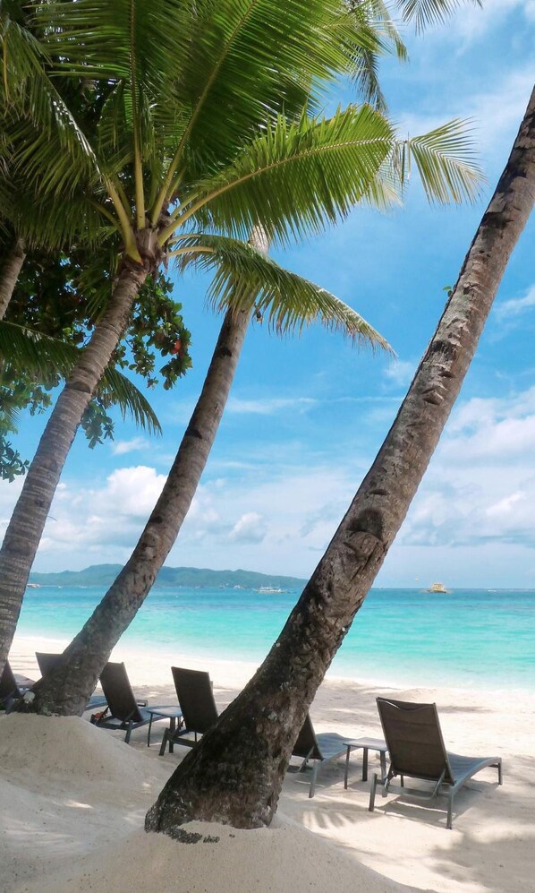 En la playa, camastros y sombrillas