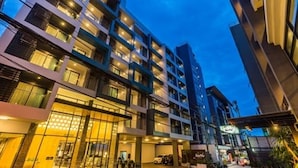 A multi-story hotel with a modern design, featuring balconies and large windows. - Sea Me Spring Tree Hotel - Adults only (Pattaya)