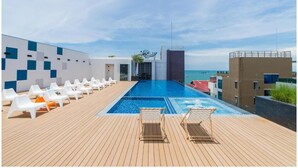 A rooftop pool area with lounge chairs and a view of the sea. - Sea Me Spring Tree Hotel - Adults only (Pattaya)