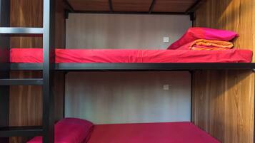 A bunk bed with red bedding and a wooden headboard.