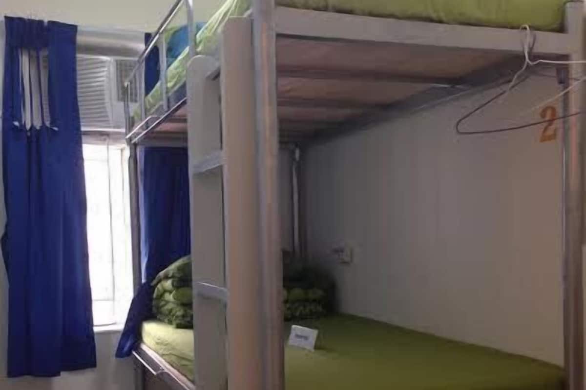 Ein Schlafraum mit Etagenbetten, einem Fenster, Vorhängen und der Zahl '2' an der Wand.