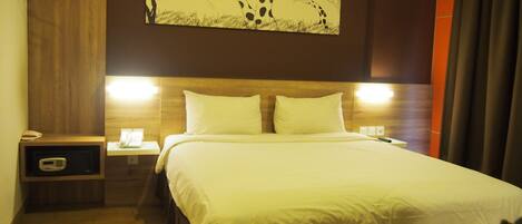 Una habitación de hotel con cama, mesitas de noche, teléfono y una obra de arte colgada en la pared.