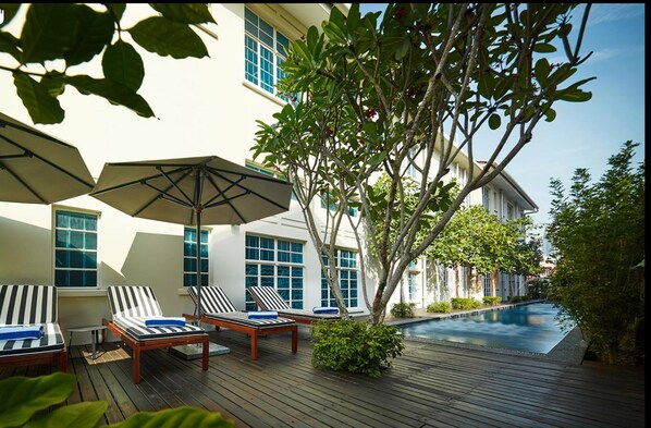 حمّام سباحة خارجي، مظلات على حمّام السباحة، مقاعد للتشمس