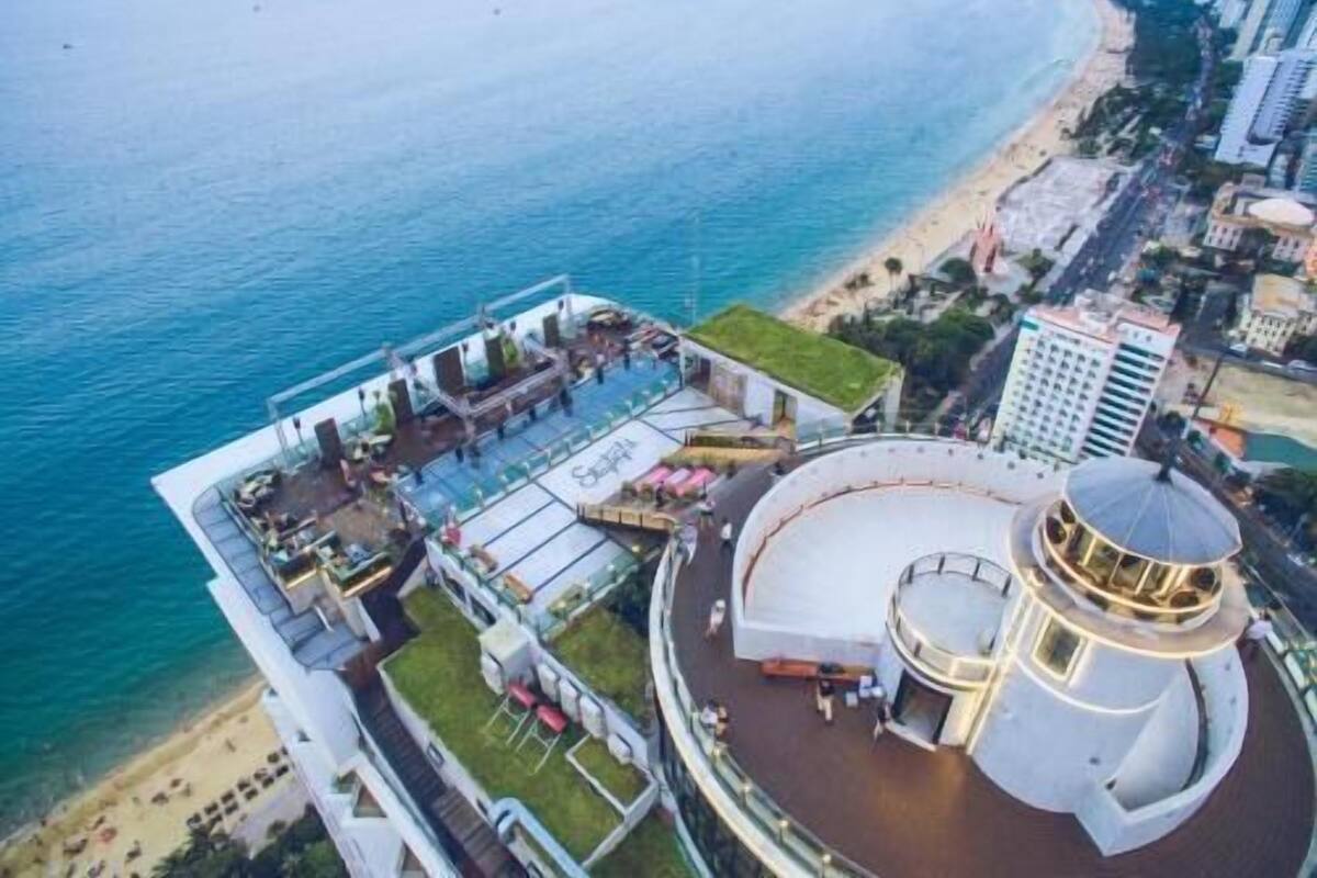 A cruise ship with a deck area, a circular observation deck, and a beachside location.