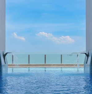A pool with a view of the ocean, a clear sky, and a sign with safety instructions. - Premier Havana Hotel (Nha Trang)