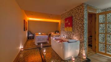 Relax in a serene spa room with a large bathtub, seat, and two comfortable beds.