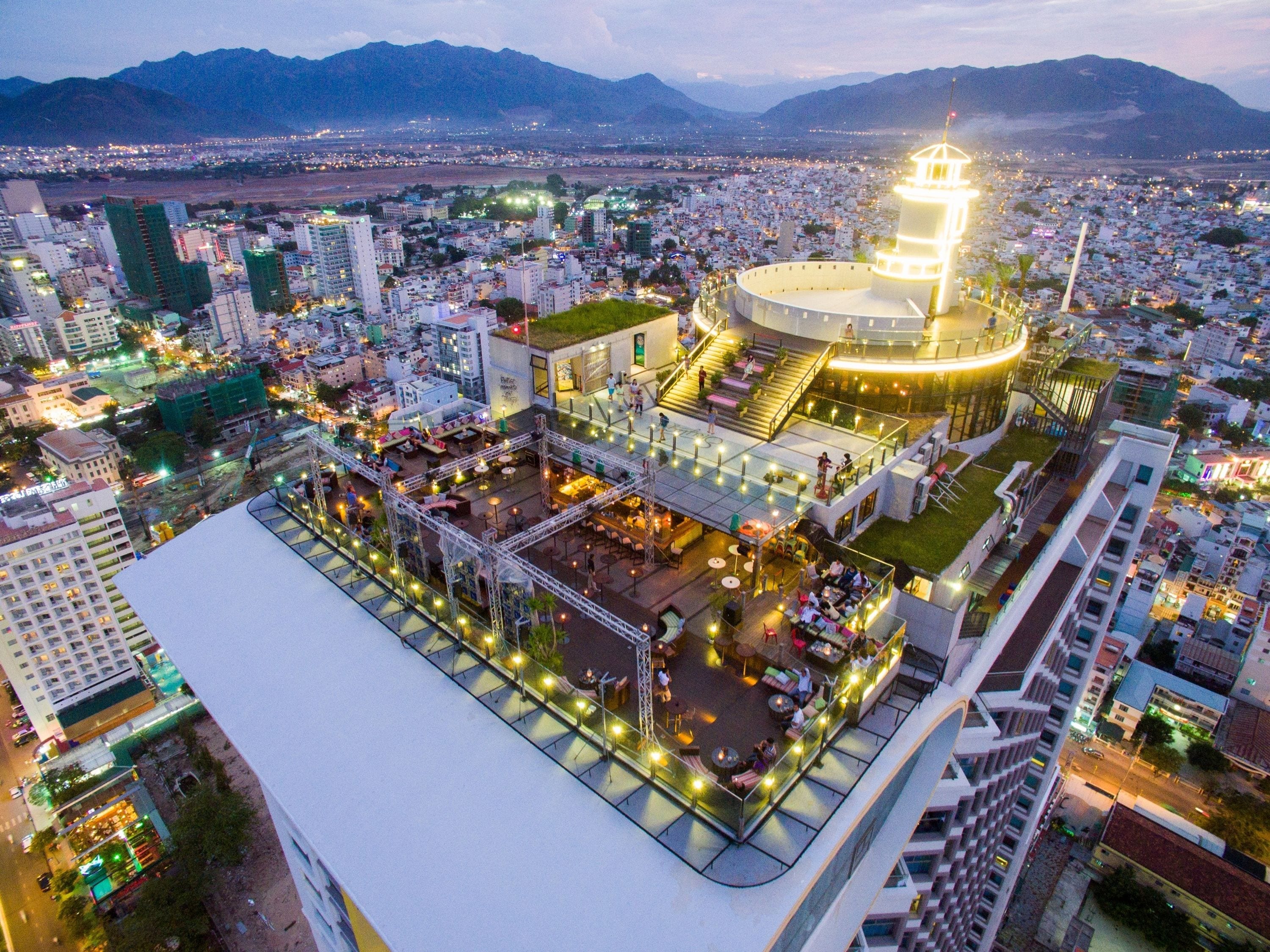 A high-rise hotel with a rooftop terrace, multiple floors, and a prominent tower structure.