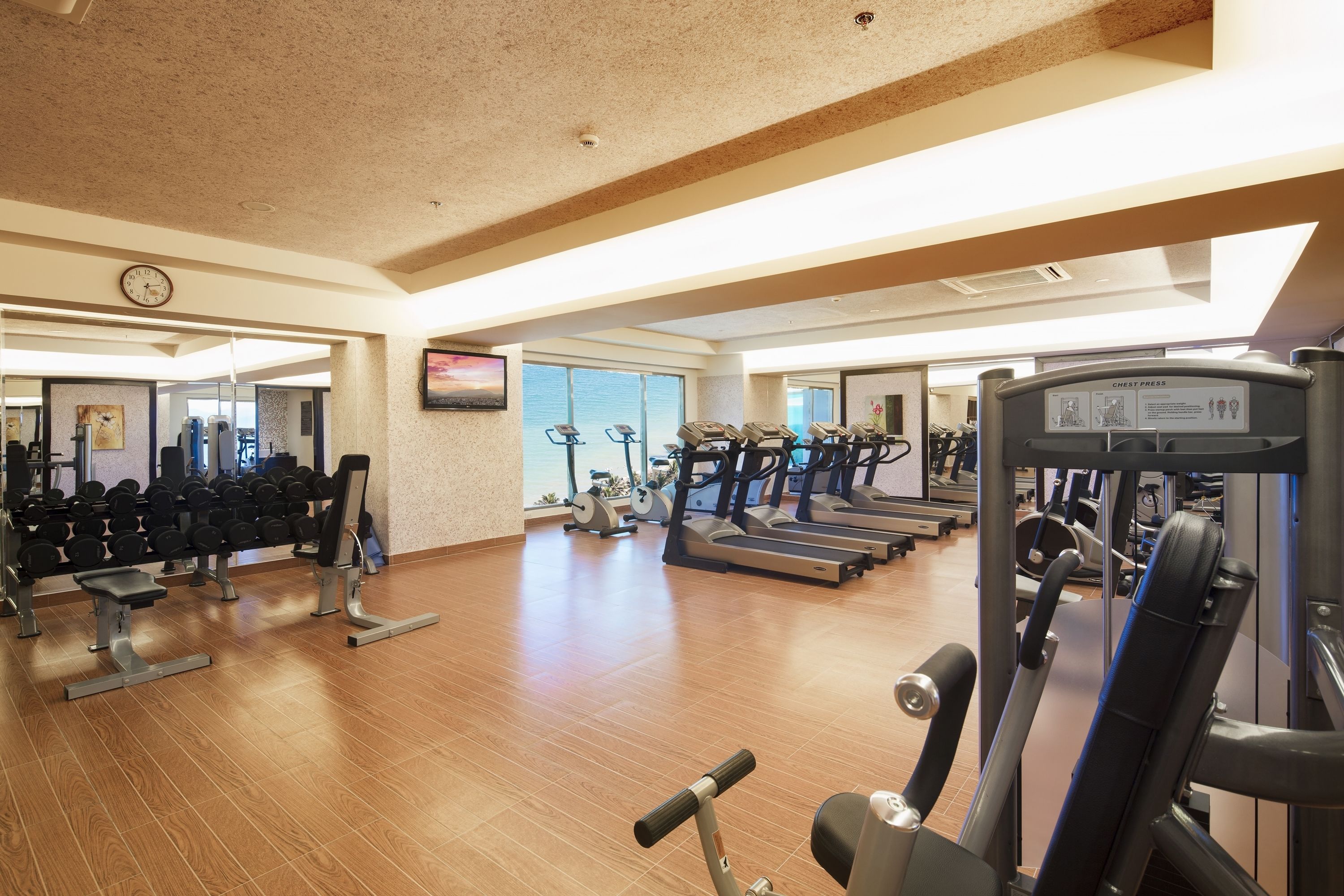 A spacious gym with treadmills, dumbbells, and weight machines.