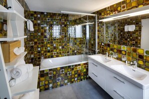 Habitación triple Deluxe | Baño | Ducha, artículos de higiene personal gratuitos y secador de pelo