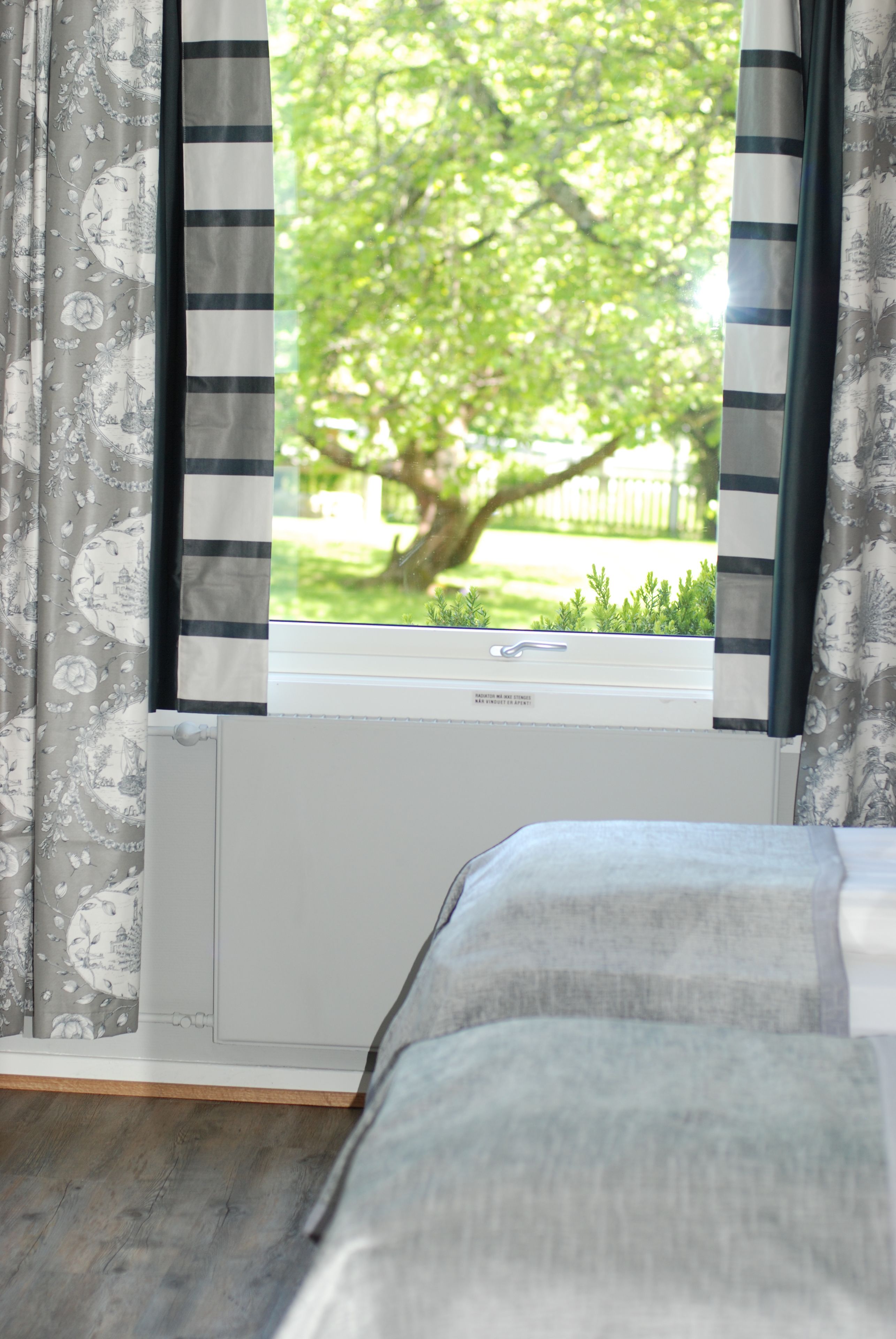 Una habitación con ventana, radiador y cama.