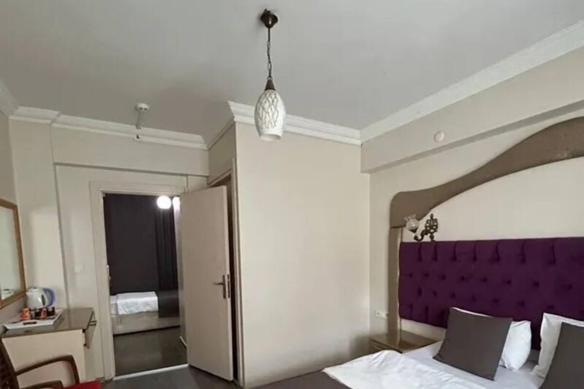 A hotel room with a bed, a desk, and a wardrobe.