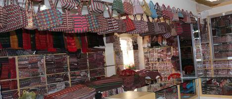 A store with shelves of patterned bags and textiles.