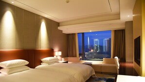 A hotel room with two beds, a sofa, a desk, and a large window with a city view. - Sorl Hotel Hangzhou (Hangzhou)
