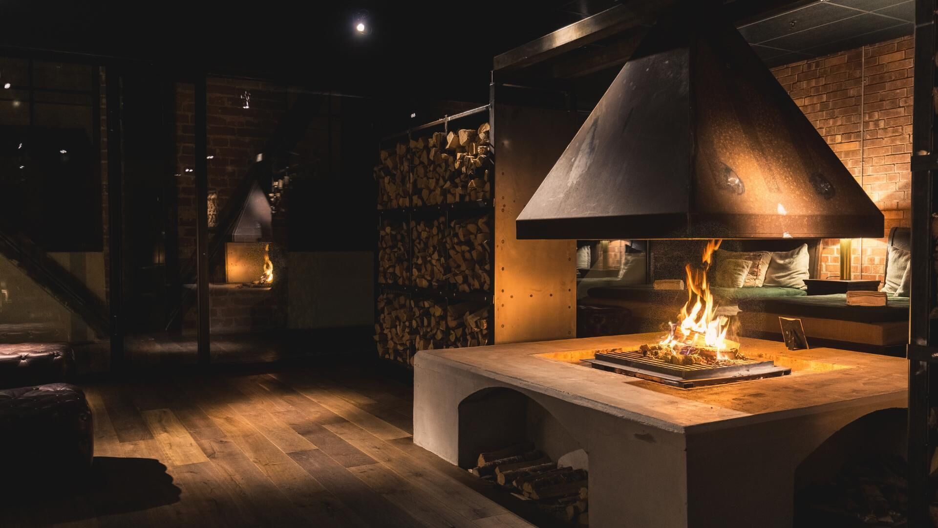 Una cocina moderna con estufa de leña, pared de ladrillo y un rincón de descanso acogedor.
