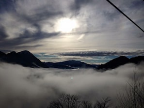 Un paysage montagneux, avec un ciel ensoleillé et des nuages.