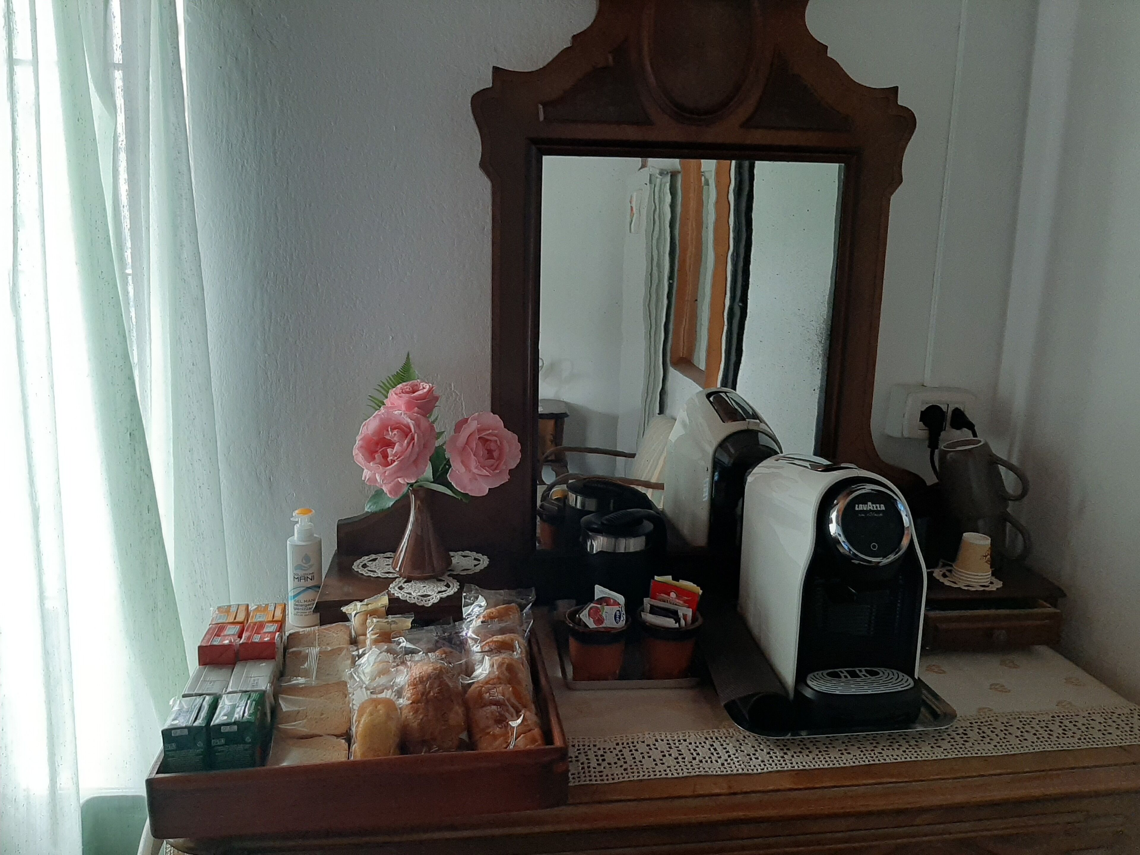 A kitchenette with a toaster, a coffee maker, and a variety of food items on the counter.