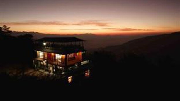 A single-story building with a flat roof, possibly a guesthouse or lodge, situated on a hillside with a view of the landscape. - Hotel New Dragon (Baluwapati Deupur)