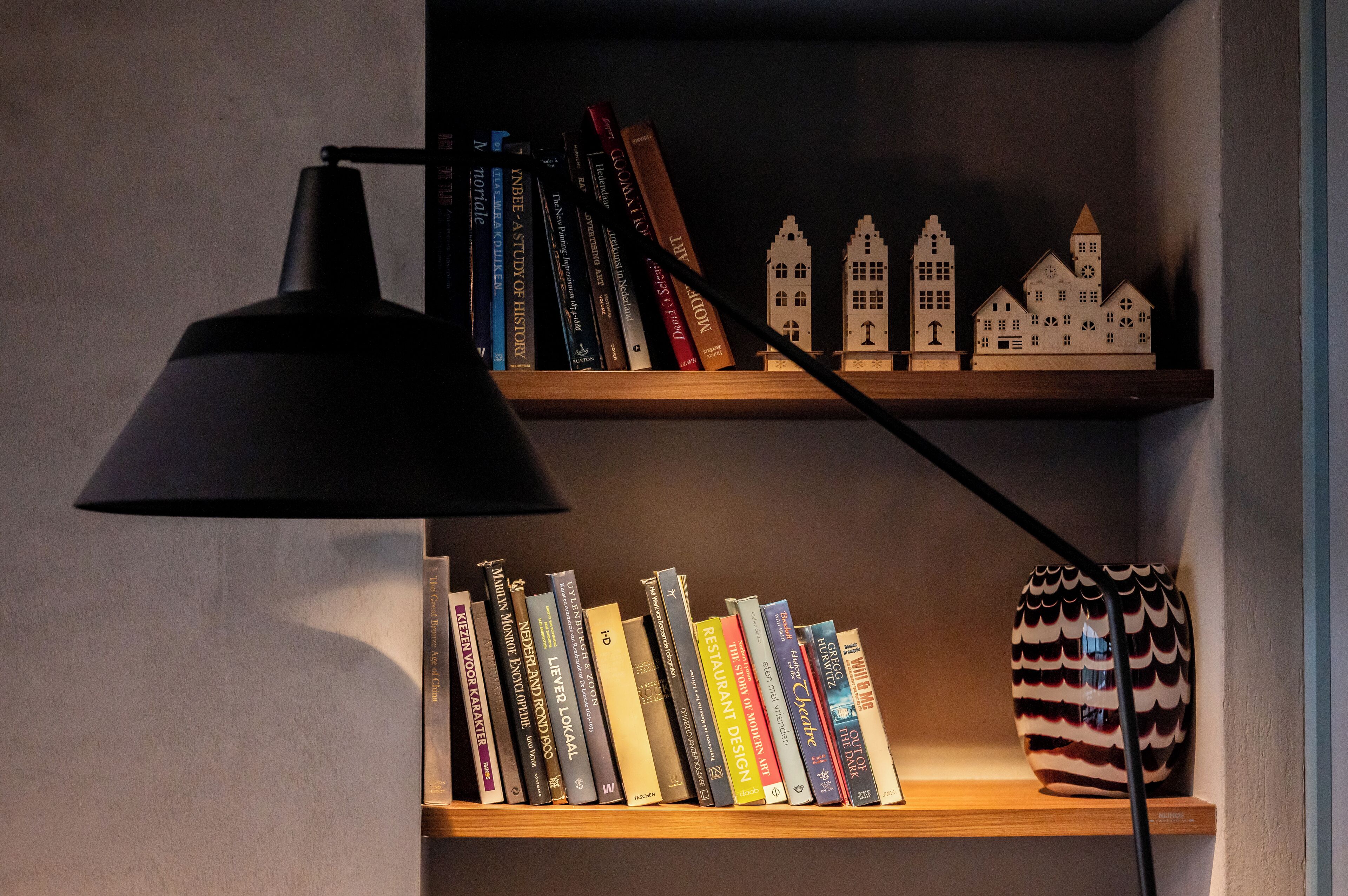 Une bibliothèque remplie de livres et de maquettes de maisons.