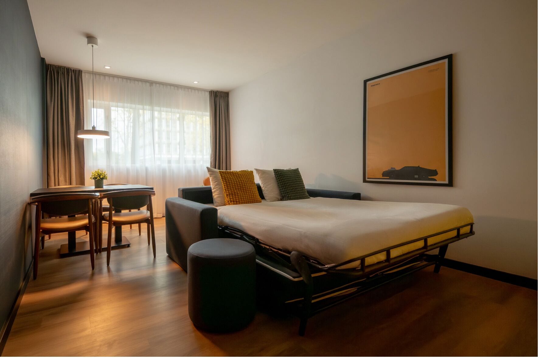 A modern hotel room with a bed, a desk, and a chair.