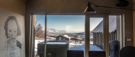 A dining area with a view of a snowy landscape and mountains.