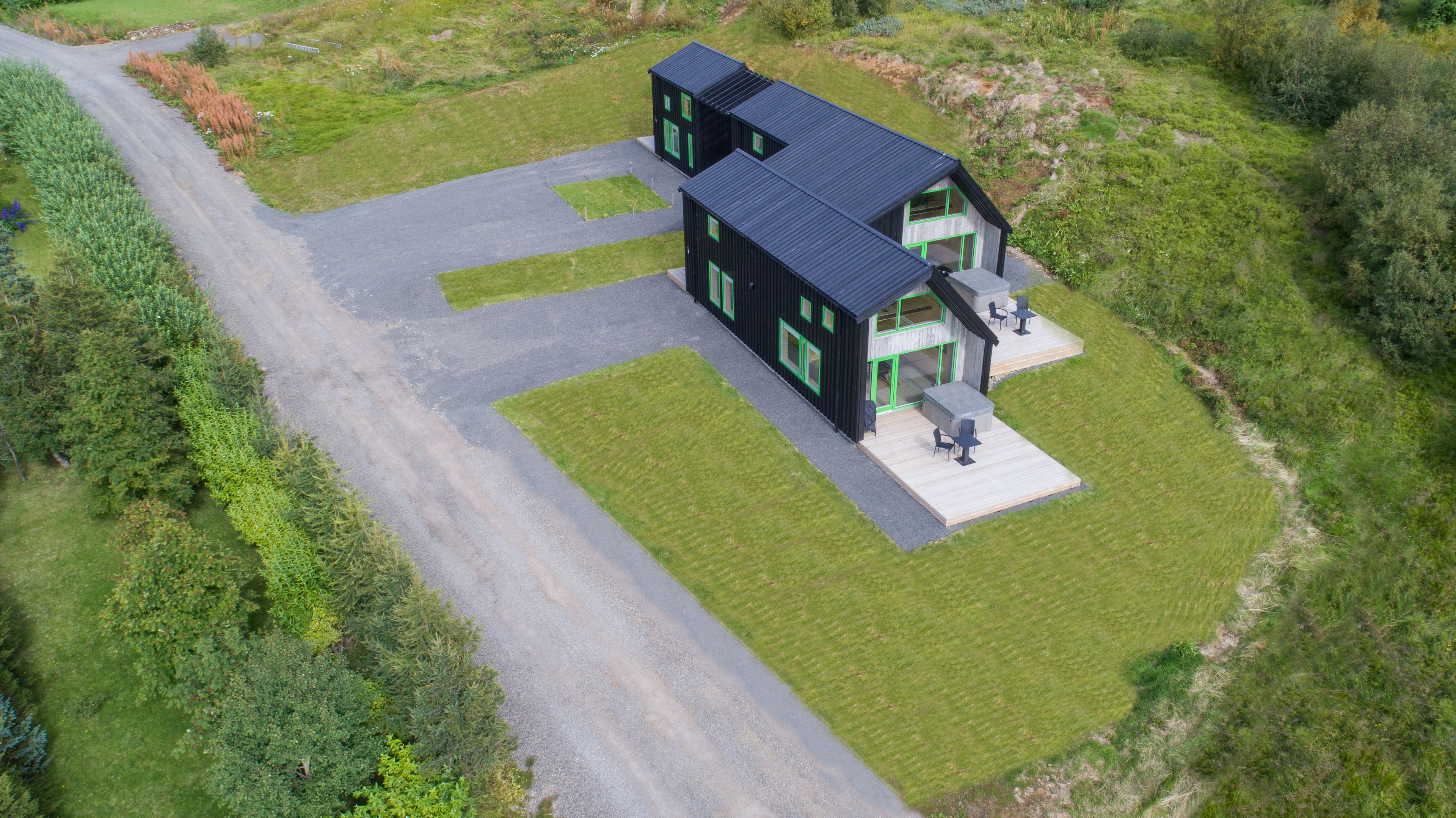 A modern two-story house with a paved driveway and a well-maintained lawn.