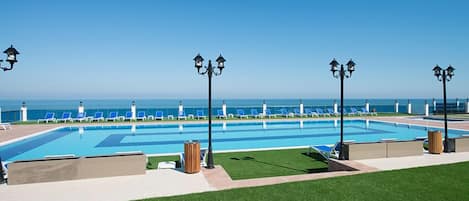 Piscine couverte, piscine extérieure, parasols de plage, chaises longues