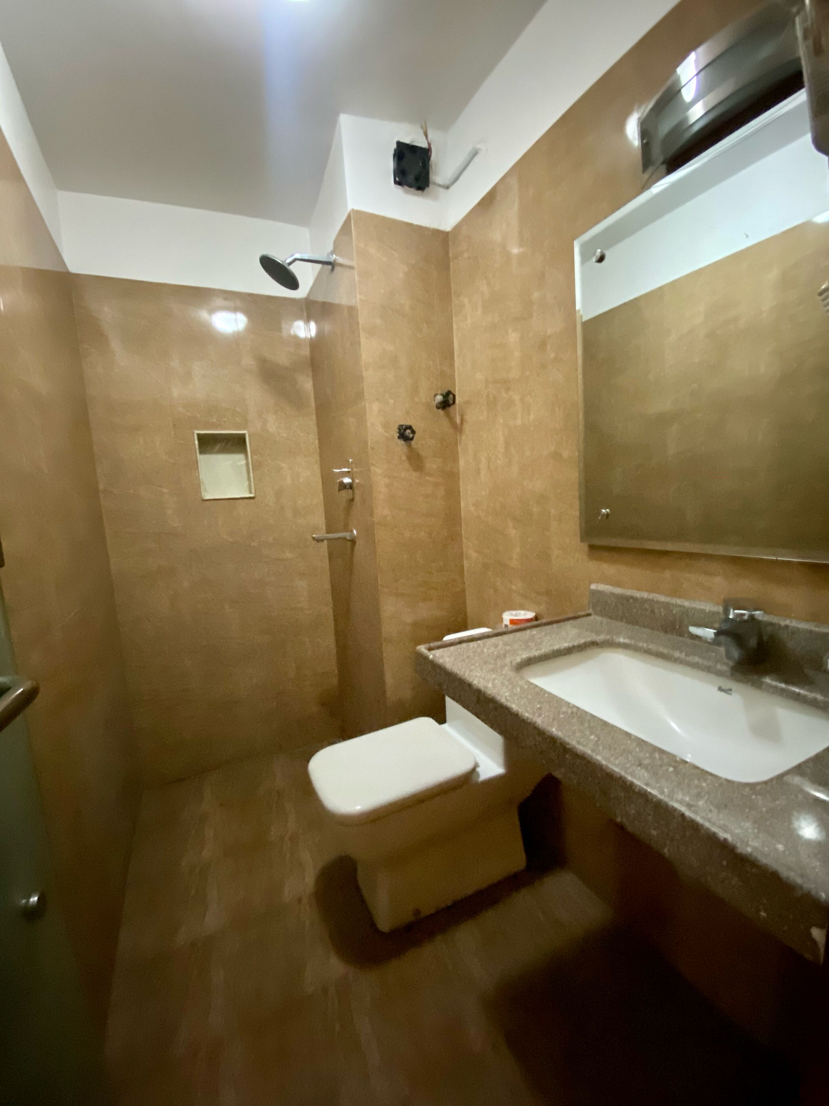 A bathroom with a shower, a sink, and a toilet.