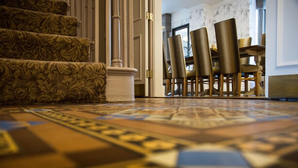 A carpeted staircase leading to a dining area with chairs and a table. - Arden House (Stratford-upon-Avon)