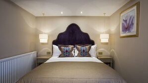A neatly made bed with a dark headboard, two bedside lamps, and a framed picture on the wall. - Arden House (Stratford-upon-Avon)