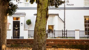 A white building with a black door and a small tree in front. - Arden House (Stratford-upon-Avon)
