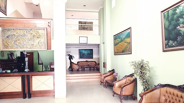 A lobby with a reception desk, a staircase leading to an upper level, and a seating area with leather sofas. - Hotel Fiducia Otista 153 (Jakarta)