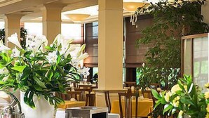 Disposição de buffet com diversos alimentos e um grande arranjo floral.