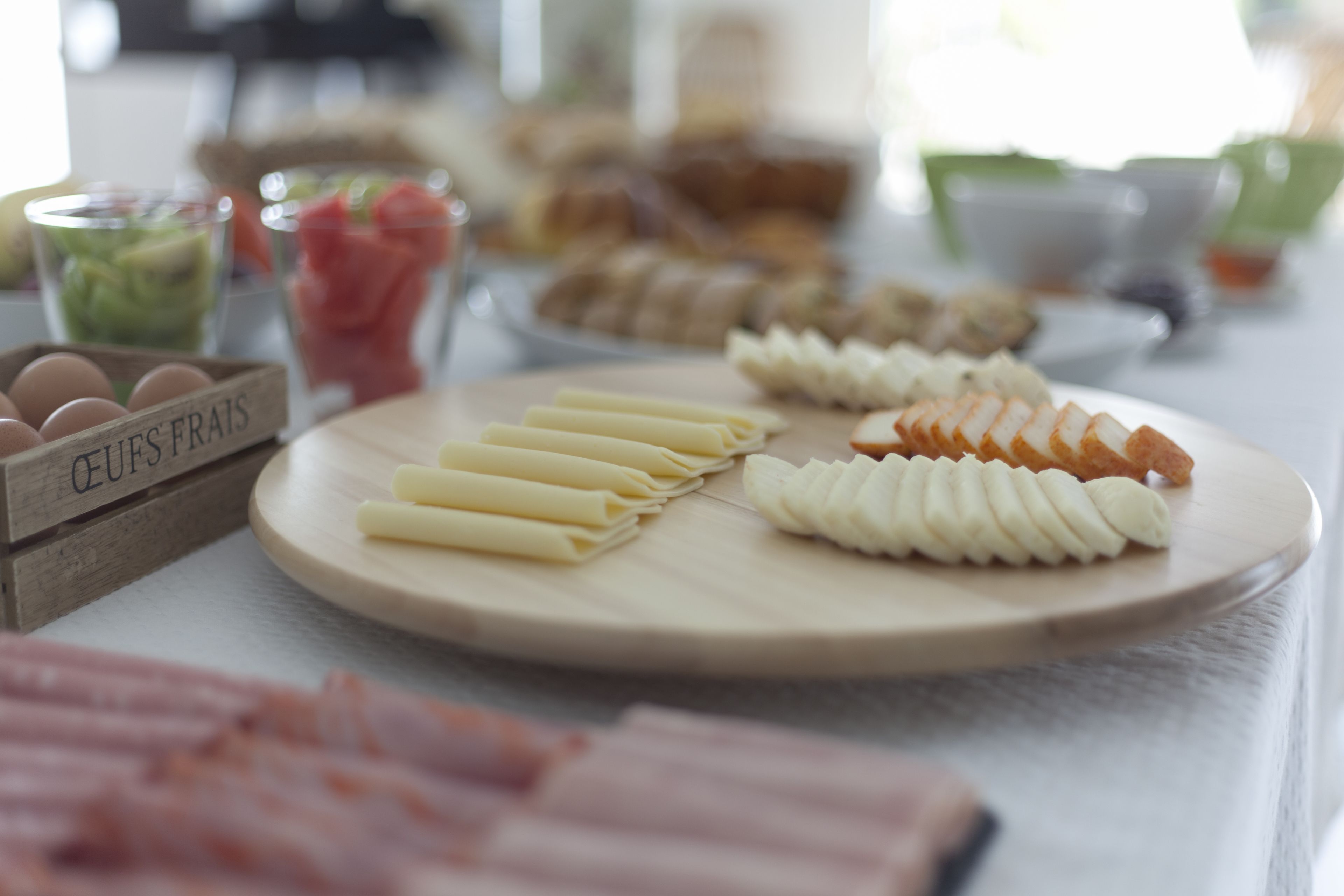 A breakfast buffet with various food items including eggs, pastries, and fruits.