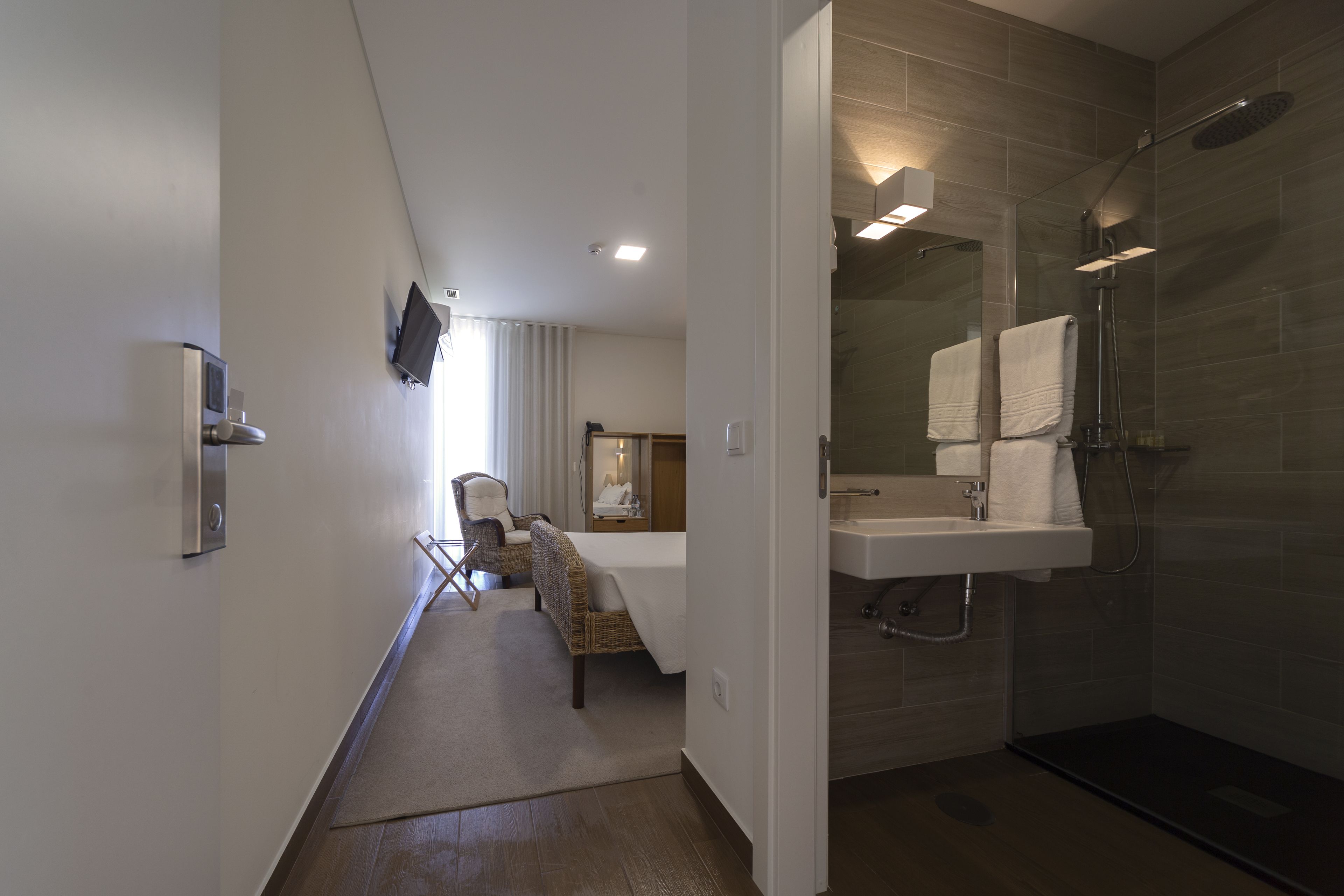 Un baño moderno con ducha de vidrio, lavamanos y espejo.