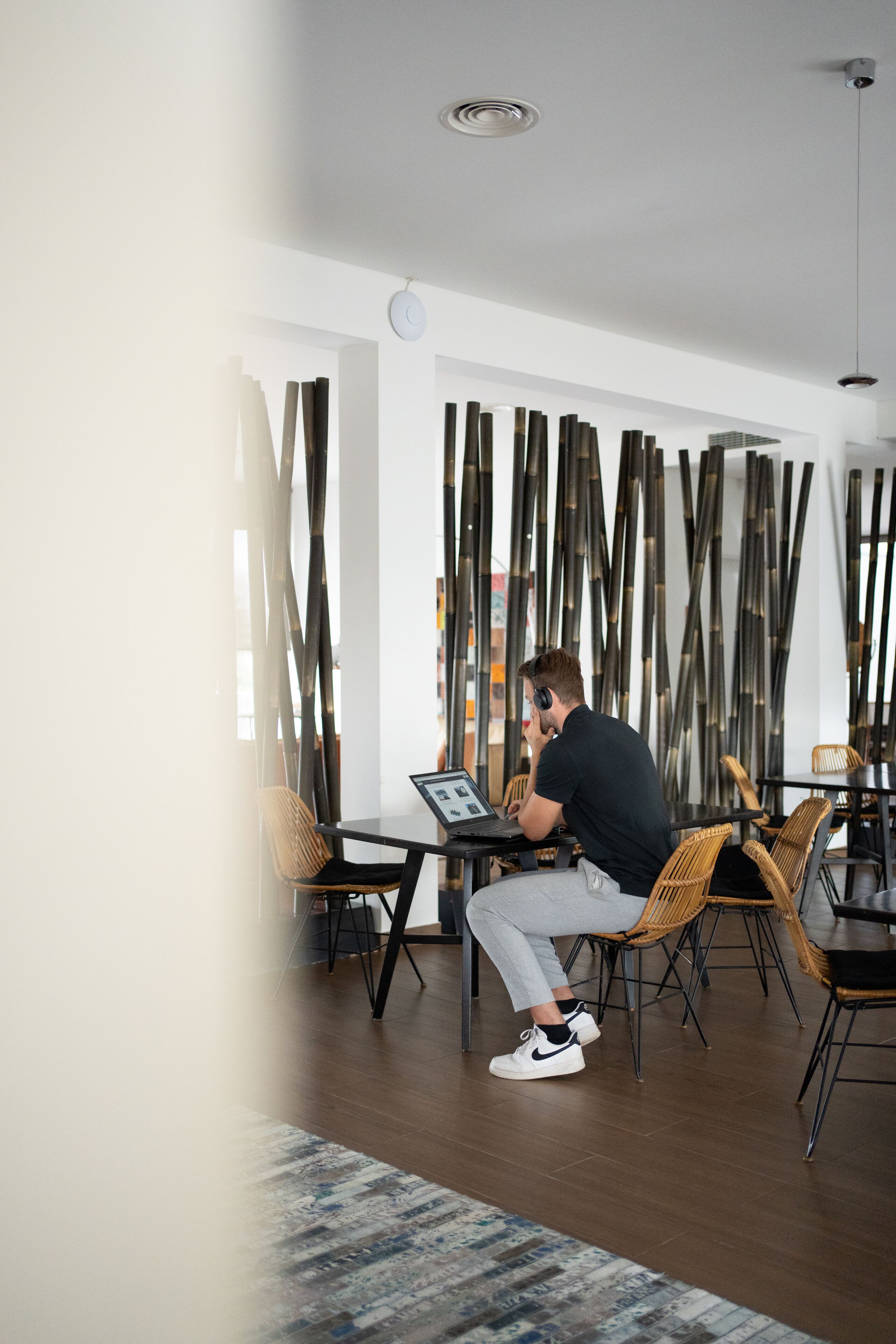 A modern interior with a person using a laptop at a table.