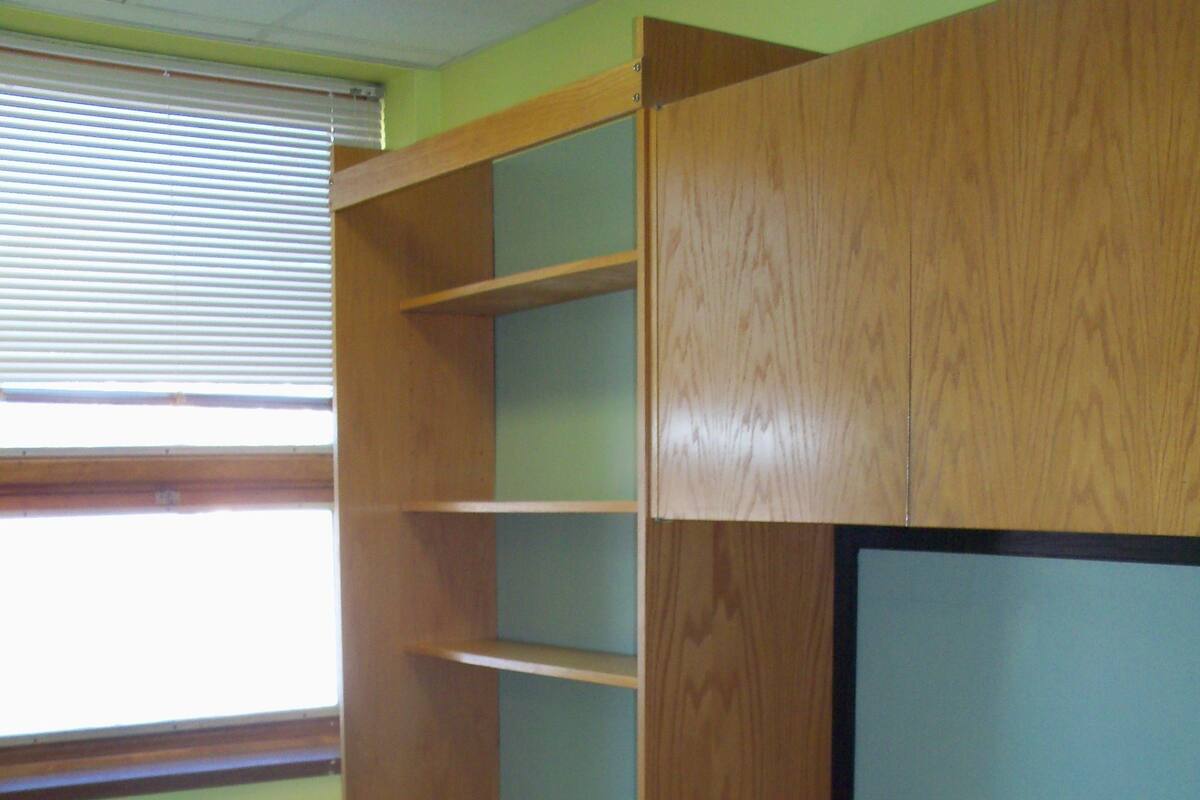 Ein Schlafraum im Studentenwohnheim-Stil mit einem Etagenbett, einem Schreibtisch und einem Stuhl.