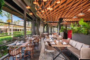 Un restaurant amb terrassa, sostre de fusta i grans finestres.