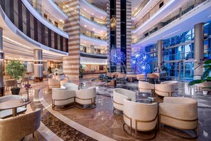 A multi-level hotel lobby with seating areas, a central column, and a glass facade. - Leodikya Kirman Premium - Ultra All Inclusive (Alanya)
