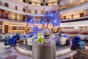 A multi-level hotel lobby with a central round table, seating areas, and a bar. - Leodikya Kirman Premium - Ultra All Inclusive (Alanya)