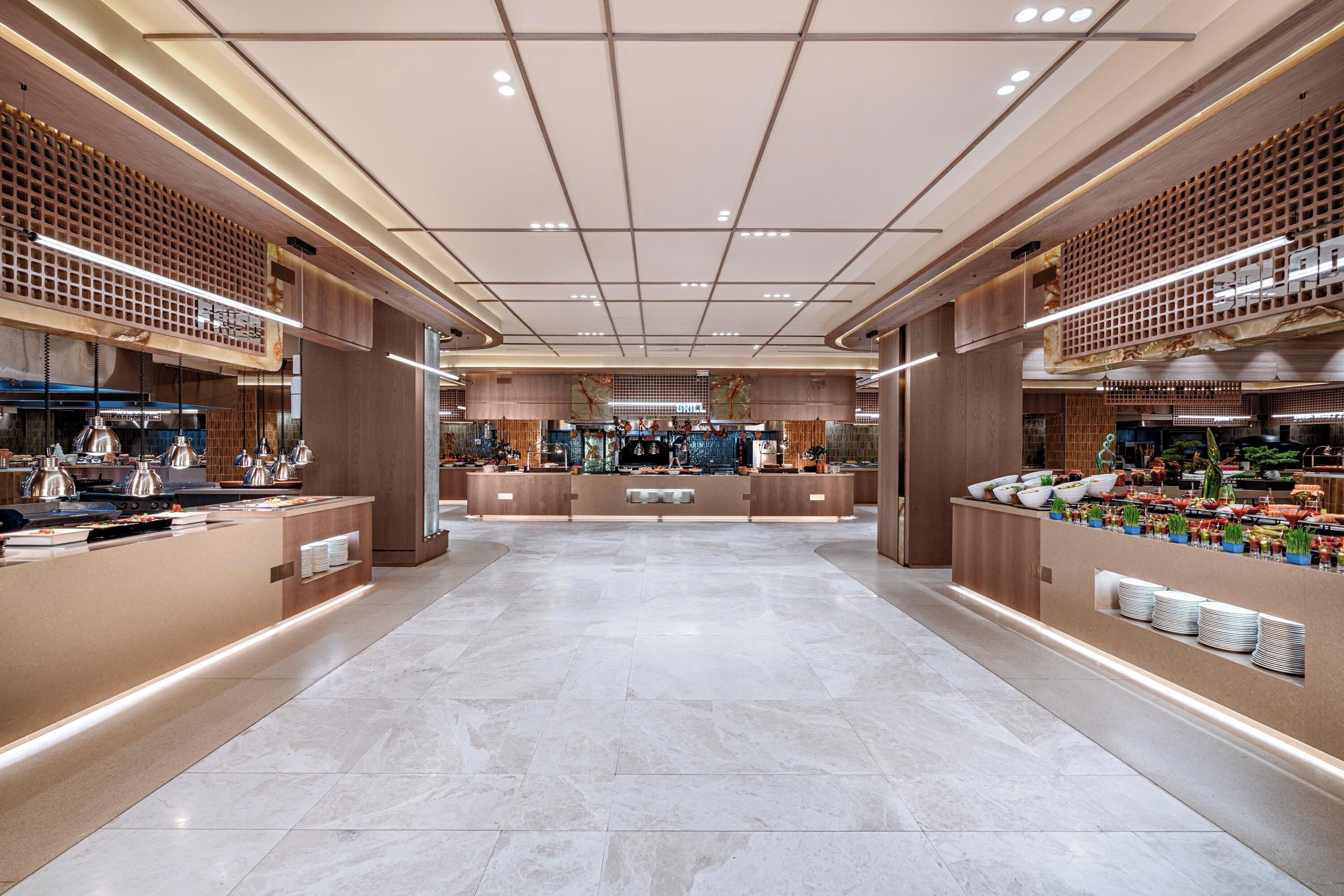 A spacious lobby with a central reception desk, a buffet area, and a seating area.