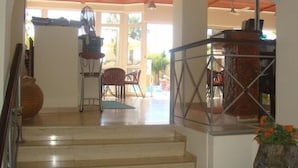 Una scala conduce a un balcone con vista sull'esterno. Sul balcone ci sono sedie e un tavolo.