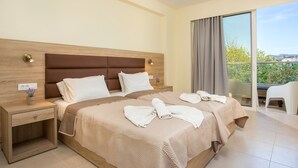 Una camera d'hotel con un letto grande, un comodino, una sedia e un balcone con vista.