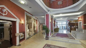 Amplio vestíbulo de hotel con una escalera central, una recepción y un letrero de centro médico.