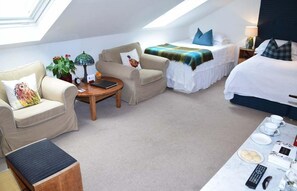 A hotel room with a high ceiling, a bed, a sofa, a small table, and a dining area with a table set for breakfast. - The Townhouse (Perth)