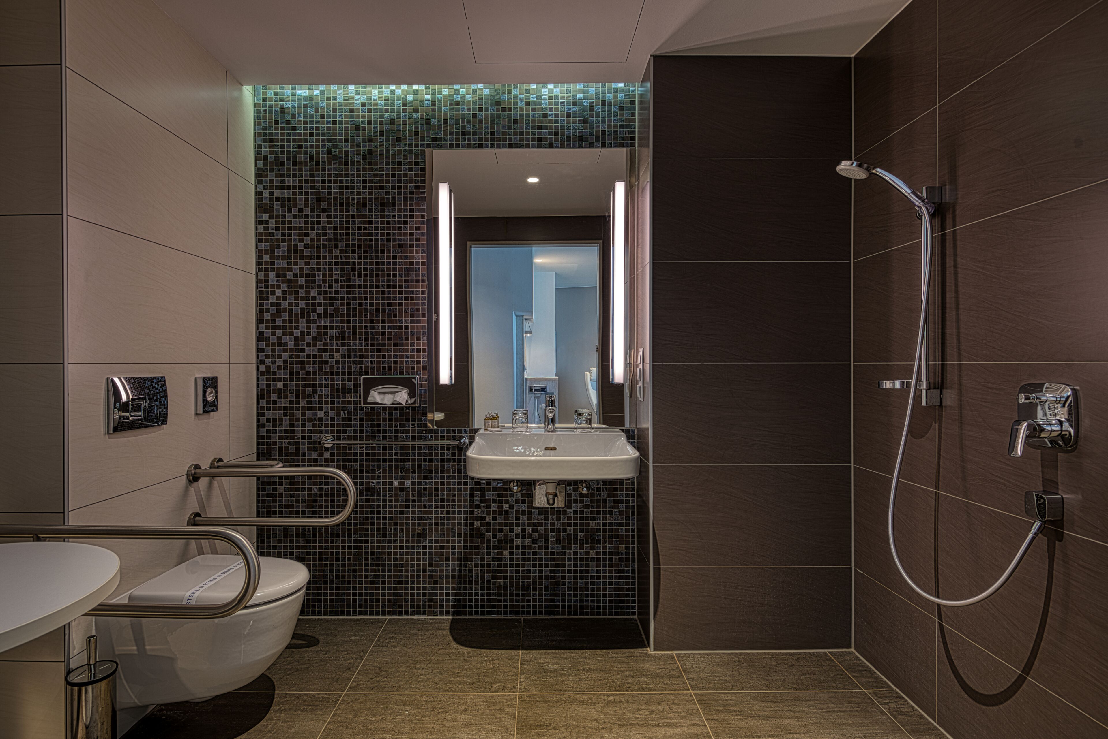 A modern bathroom with a toilet, sink, and shower.