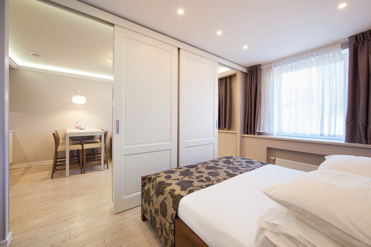 A hotel room with a bed, a desk, and a chair.