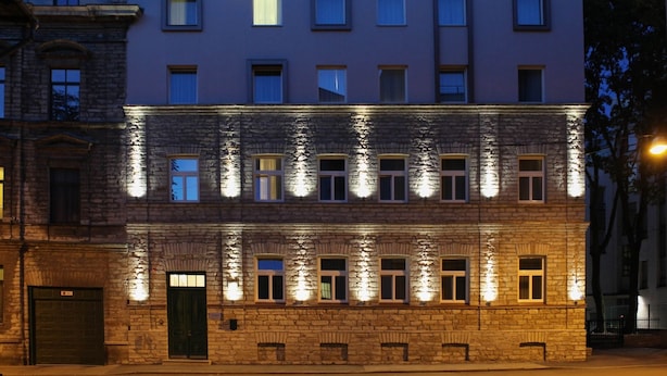 Un immeuble à plusieurs étages, doté d’une façade en pierre et de nombreuses fenêtres.